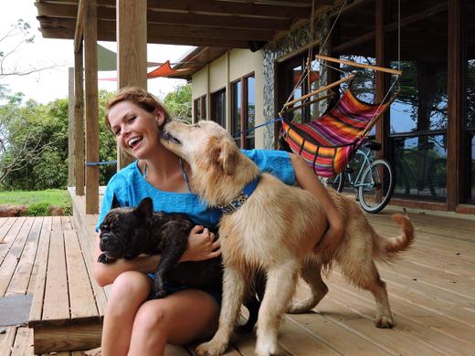 Amy laughing as Aussie licks her face while she holds Cosquilla