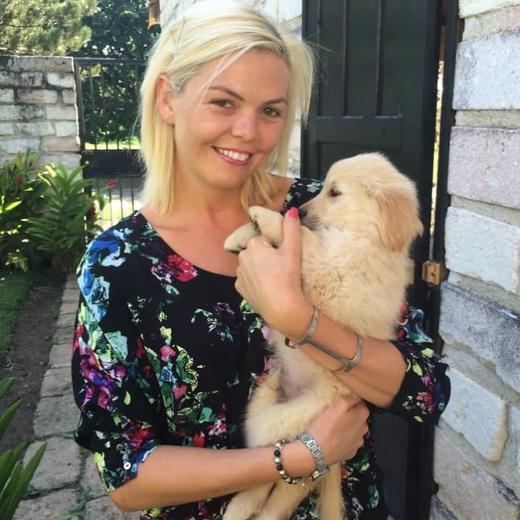 Amy holding Aussie as a fluffy golden retriever puppy